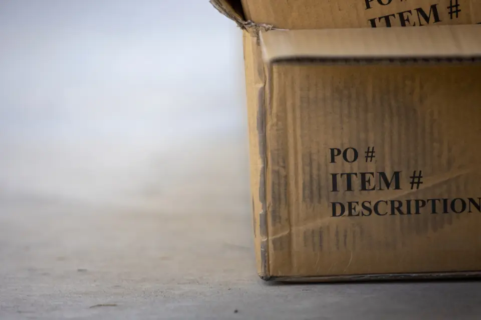 Corner of a corrugated export carton with printed PO and item fields